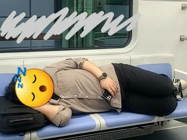 地下鉄の座席で横になって寝ている男性