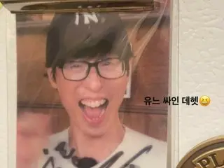 Actor Lee Dong Wook smiles after receiving a special photo card from the ``grand prize winner'' Yoo Jae Suk?