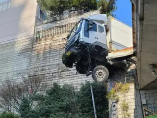A truck crashes through the wall of an elevated road and comes to rest with its front end suspended in the air - South Korea