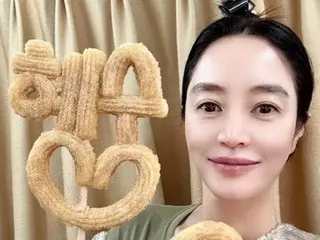 Actress Kim Hye Soo takes a selfie with a gift of churros