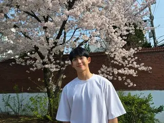 Actor Jung HaeIn, smiling sweetly with cherry blossoms in the background... "Have a great weekend"