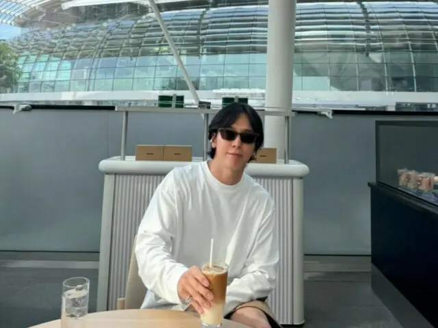 "CNBLUE" Jung Yong Hwa, enjoying an iced cafe latte with Marina Bay Sands in the background
