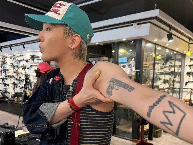 G-DRAGON (BIGBANG) visits a gun shop and shows off the gun tattoo on his arm