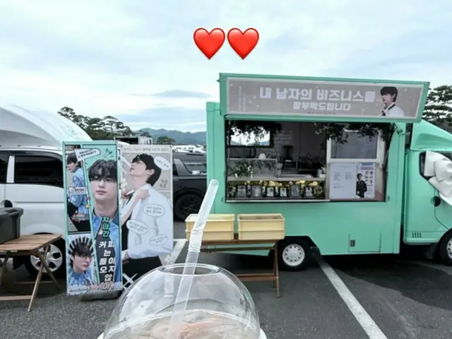 Actor Byeon WooSeok makes a pair of hearts while holding drinks as a gift from a cafe car