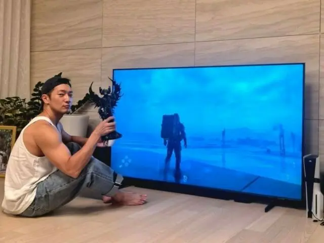 Son Sukku is sitting on the floor in front of the TV, absorbed in playing games... Lee Dong Hwi commented, "Shall I send you a TV stand?"